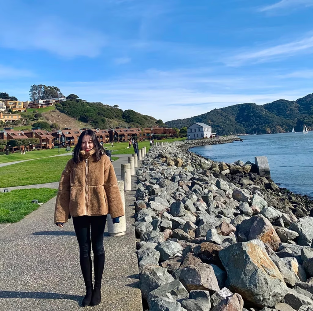Connie Liu walking along a rocky waterfront